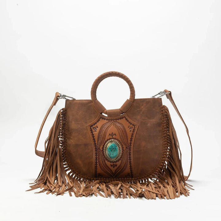 Brown leather handbag with fringe and turquoise stone on a white background