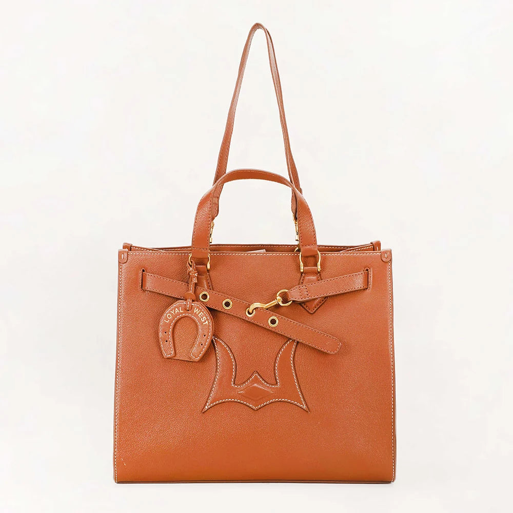 A tan leather tote bag with double top handles, a front decorative strap, a hanging horsebit charm, and a large stitched horsebit motif on the front, photographed against a plain white background.