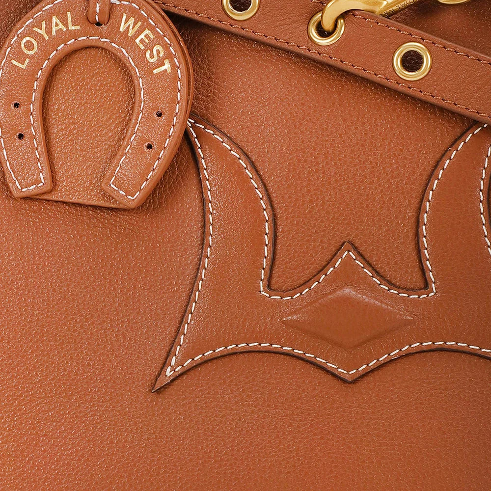 Close-up of a brown leather product with 'Loyal West' branding and horseshoe emblem.