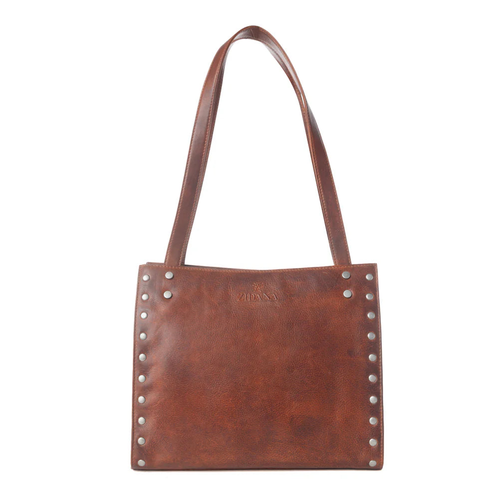 Brown leather handbag with studs on a white background