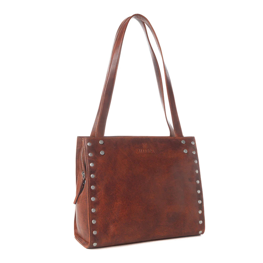 Brown leather handbag with studs on a white background