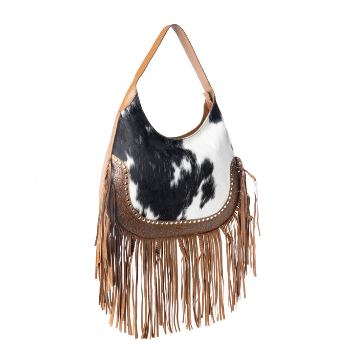 bag with cow print and fringe details on a white background