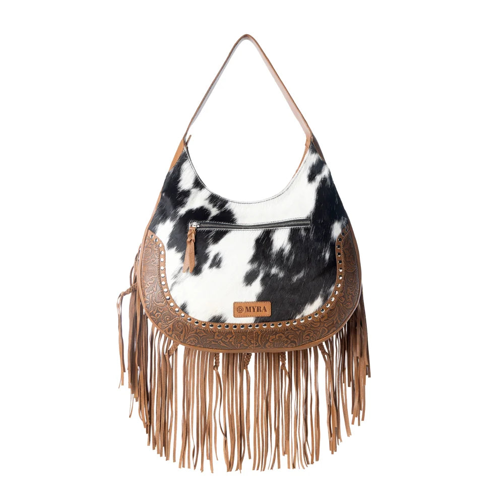 bag with cow print and fringe details on a white background