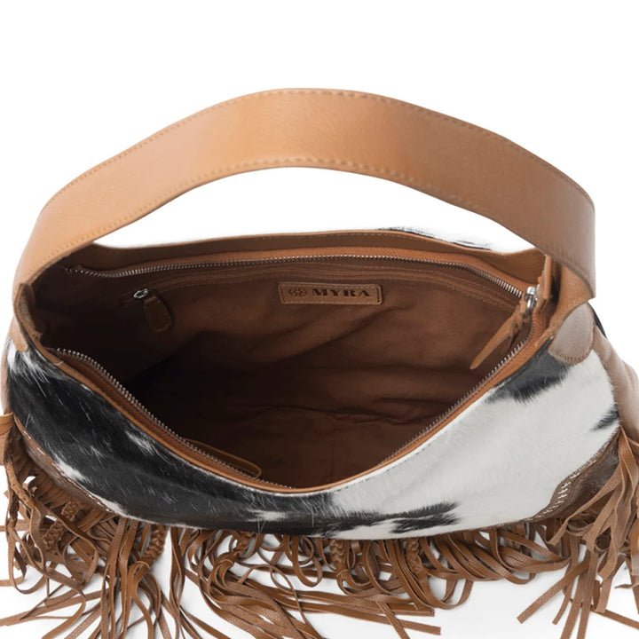 Brown leather handbag with cowhide pattern and fringes on a white background