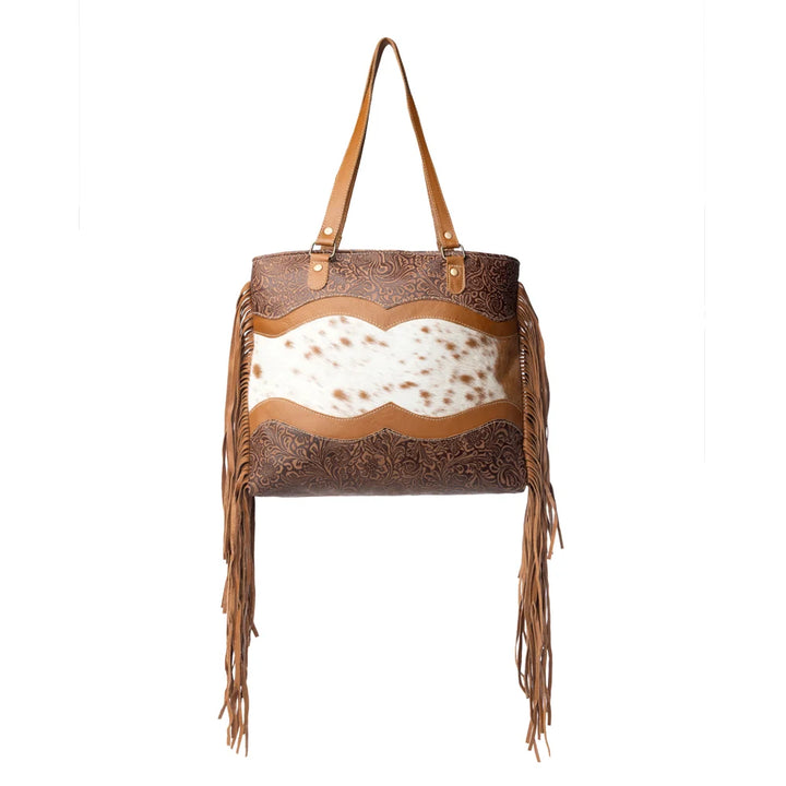 Brown leather handbag with fringe and cowhide on a white background